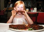 Avery Flotte, 6, chomps on some hot ribs at TJ Ribs.